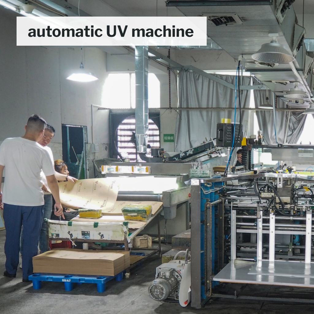 Workers assembling and inspecting packaging boxes on a production line.