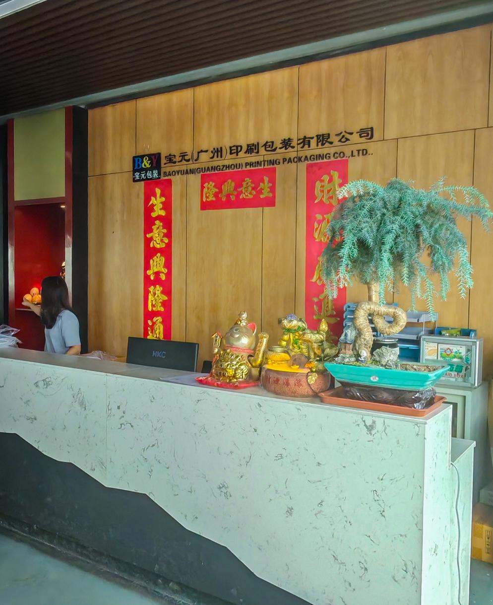 Front desk at Baoyuan Printing and Packaging Co., Ltd., showcasing company decor and branding.