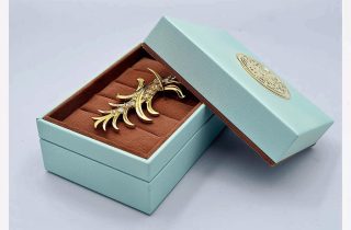 Elegant mint green jewelry box with brown velvet insert, perfect for brooches and fine jewelry.